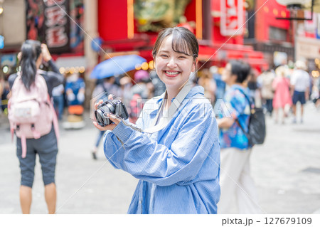 大阪の繫華街で趣味の写真撮影を楽しむ若くて可愛大阪の繫華街で趣味の写真い女性イメージ｜大阪府内で撮影 127679109