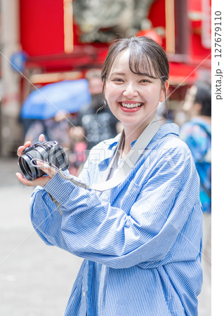 大阪の繫華街で趣味の写真撮影を楽しむ若くて可愛大阪の繫華街で趣味の写真い女性イメージ｜大阪府内で撮影 127679110
