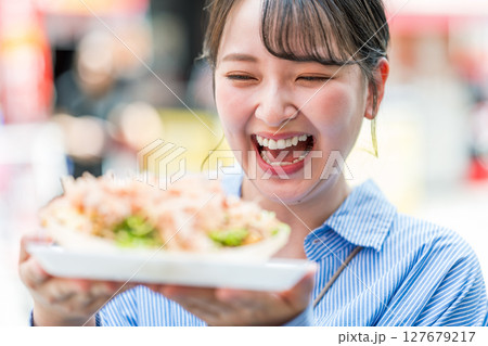 屋外でたこ焼きを食べる女性｜大阪府大阪市道頓堀にて 127679217