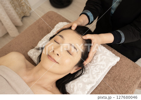 ヘッドマッサージの施術を受ける女性 ヘッドマッサージの施術を受ける女性 127680046