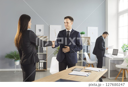 Businessman Shaking Hands With Client Or Coworker In Office Meeting Businessman Shaking Hands With Client Or Coworker In Office Meeting 127680247