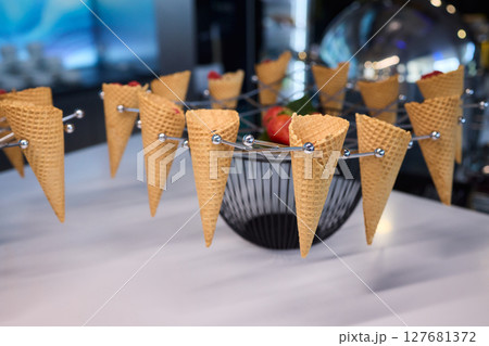 Elegant and Beautiful Dessert Presentation Featuring Ice Cream Cones Alongside Fresh Strawberries 127681372