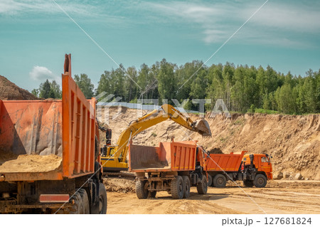 The process of loading sand in a sand quarry. Trucks are waiting for cargo. 127681824