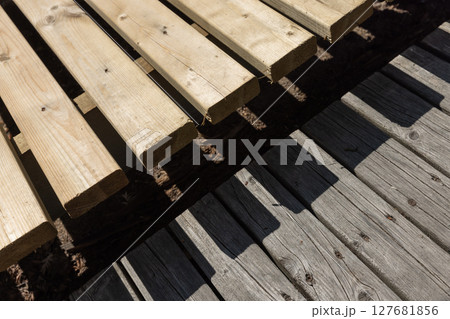 Sunlit wooden planks form a detailed architectural pattern Sunlit wooden planks form a detailed architectural pattern 127681856