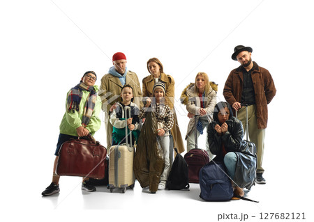Diverse group of travelers with luggage symbolizing global migration and economic hardship 127682121
