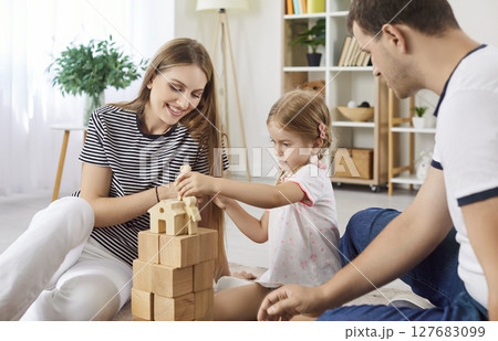 Family With Child Playing With Wooden Toys Together At Home 127683099