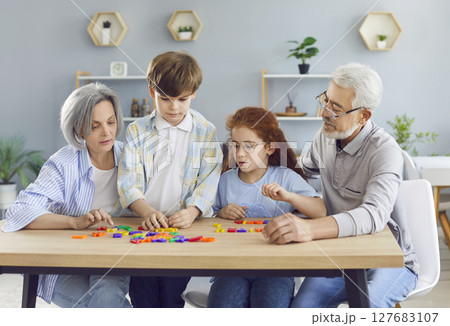 Grandparents And Grandchildren Learning And Playing Together At Home Grandparents And Grandchildren Learning And Playing Together At Home 127683107
