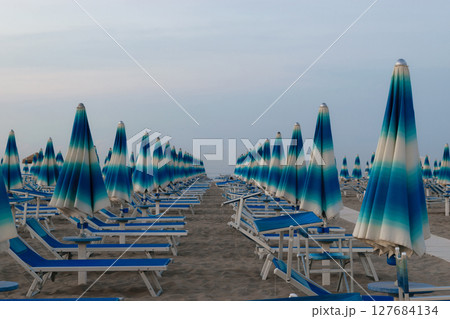 Parasols and sunbeds in Rimini resort beach Parasols and sunbeds in Rimini resort beach 127684134
