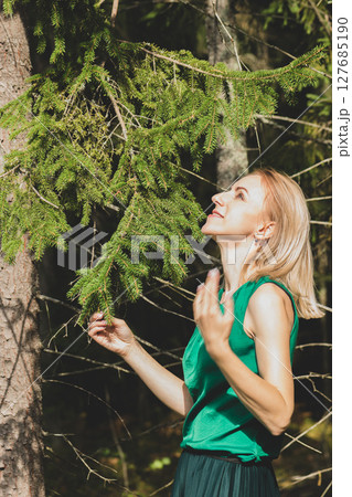 Woman enjoy sun near the spruce tree Woman enjoy sun near the spruce tree 127685190