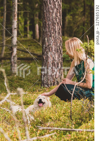 Woman playing with dog in forest Woman playing with dog in forest 127685192