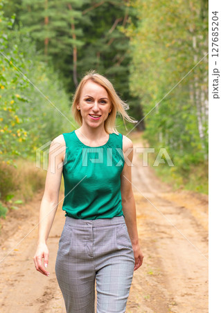 Woman walking on forest road Woman walking on forest road 127685204