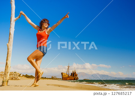 Tourist woman on beach enjoying vacation 127685217