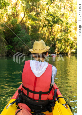 Woman with red life jacket swim with kayak in Thailand 127685304