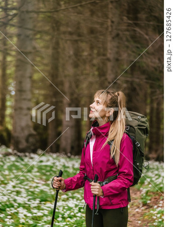 Woman Hiking through Spring Forest Glade 127685426