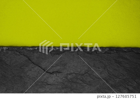 Abstract background composition of divided in the half matt dark yellowish green color paper and black stone with copy space 127685751