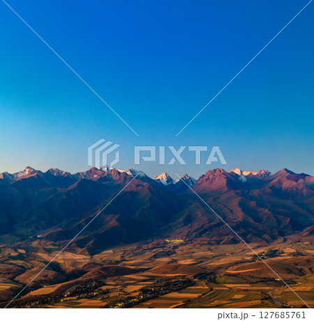Majestic mountain range with snow-capped peaks at twilight 127685761