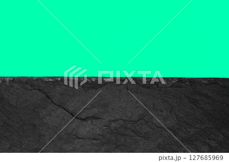 Abstract background composition of divided in the half vivid soft green color paper and black stone with copy space 127685969