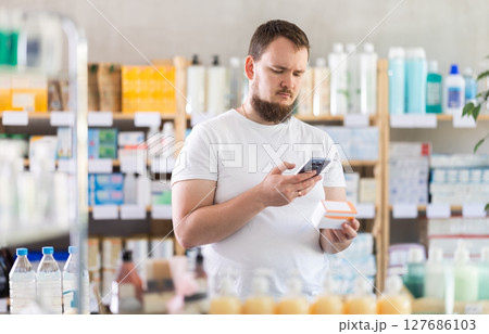 Young man scanning qr code of pills 127686103