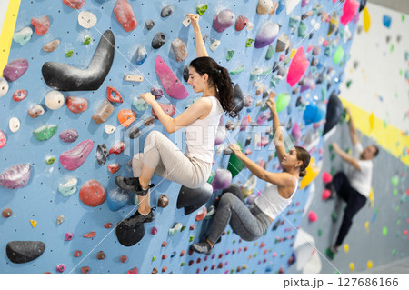 Young woman doing rock climbing on climbing wall Young woman doing rock climbing on climbing wall 127686166