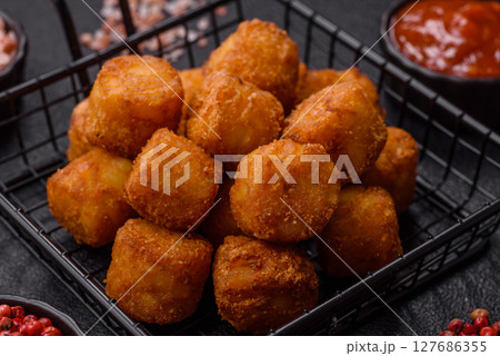 Cheese or potato croquettes, balls fried in breading with salt, spices Cheese or potato croquettes, balls fried in breading with salt, spices 127686355
