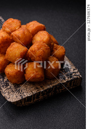 Cheese or potato croquettes, balls fried in breading with salt, spices 127686374