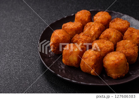 Cheese or potato croquettes, balls fried in breading with salt, spices 127686383