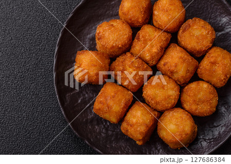 Cheese or potato croquettes, balls fried in breading with salt, spices 127686384