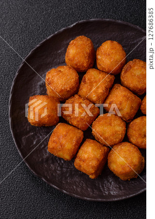 Cheese or potato croquettes, balls fried in breading with salt, spices 127686385