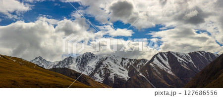 Dramatic snow-capped mountains in serene outdoor setting Dramatic snow-capped mountains in serene outdoor setting 127686556