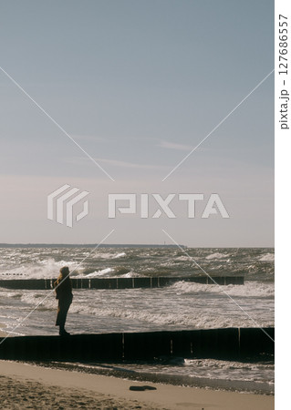 man is walking along the beach, and the sun's rays fall on him. man is walking along the beach, and the sun's rays fall on him. 127686557