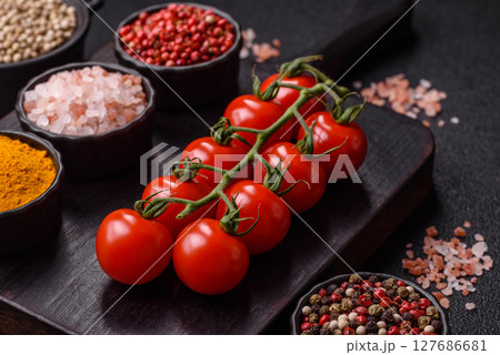 Red cherry tomatoes on a branch, a vegetable as an ingredient for making sauces Red cherry tomatoes on a branch, a vegetable as an ingredient for making sauces 127686681