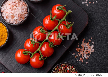 Red cherry tomatoes on a branch, a vegetable as an ingredient for making sauces Red cherry tomatoes on a branch, a vegetable as an ingredient for making sauces 127686682