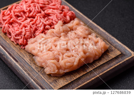Beef and chicken minced meat, ground of two types fresh raw with salt and spices Beef and chicken minced meat, ground of two types fresh raw with salt and spices 127686839