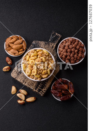 Flakes, chocolate balls and dried fruit for a hearty breakfast Flakes, chocolate balls and dried fruit for a hearty breakfast 127687039