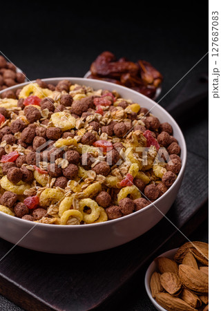 Flakes, chocolate balls and dried fruit for a hearty breakfast 127687083