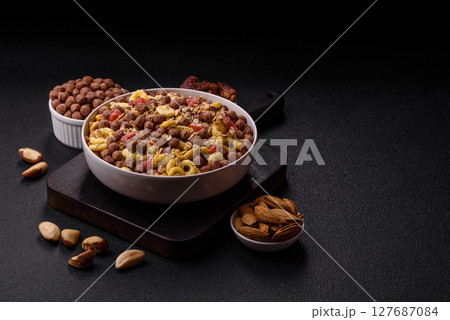 Flakes, chocolate balls and dried fruit for a hearty breakfast 127687084