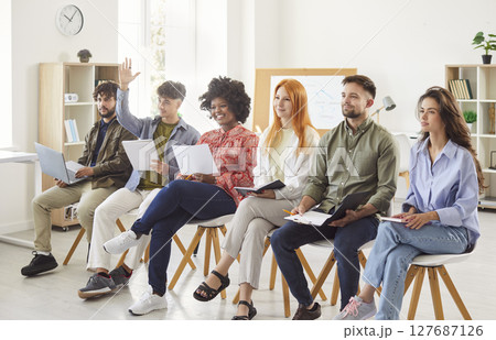Business Team Asking Questions And Raising Hands During Office Meeting Business Team Asking Questions And Raising Hands During Office Meeting 127687126