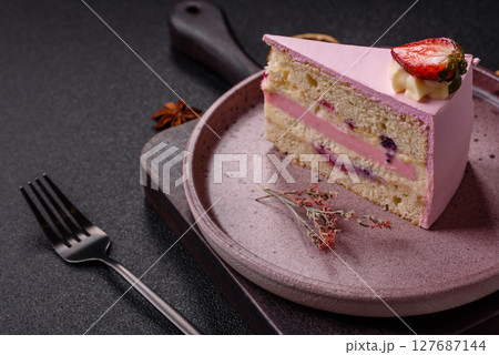 A slice of pink colored puff cake for a birthday celebration 127687144