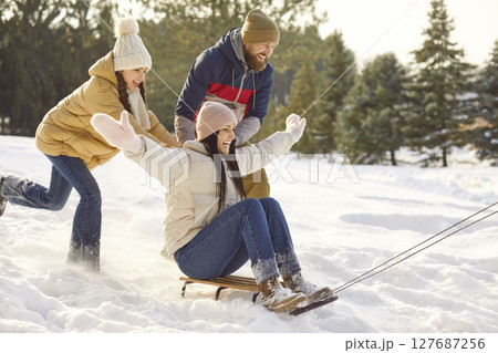 Funny parents with their teenage daughter spend time together, have fun and enjoy winter day. 127687256