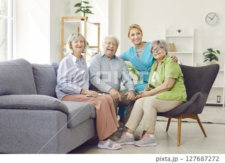 Portrait Of Happy Caregiver With Group Of Elderly Patients At Nursing Home Portrait Of Happy Caregiver With Group Of Elderly Patients At Nursing Home 127687272