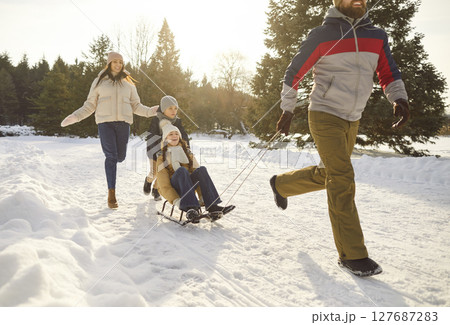 Happy active winter sporty family snow fun, sledging children in wintertime, playing  127687283