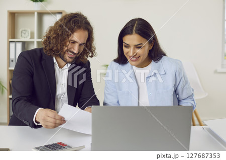 Male accountant or auditor meeting with female client at office table with laptop Male accountant or auditor meeting with female client at office table with laptop 127687353