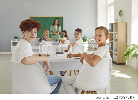 Back view of junior high school children working in classroom sitting at the desk. 127687397