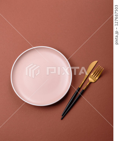 Empty ceramic plate on a monochrome brown background Empty ceramic plate on a monochrome brown background 127687503