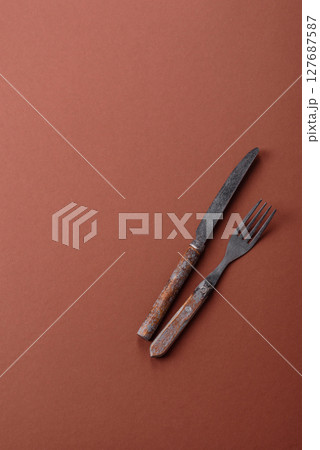 Knife and fork, cutlery on a brown dining table 127687587