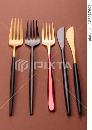 Knife and fork, cutlery on a brown dining table 127687608