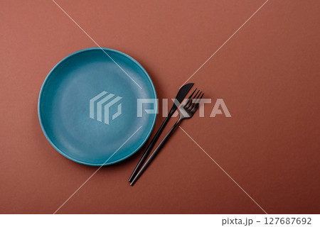 Empty ceramic plate on a monochrome brown background Empty ceramic plate on a monochrome brown background 127687692