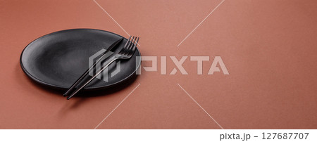 Empty ceramic plate on a monochrome brown background Empty ceramic plate on a monochrome brown background 127687707