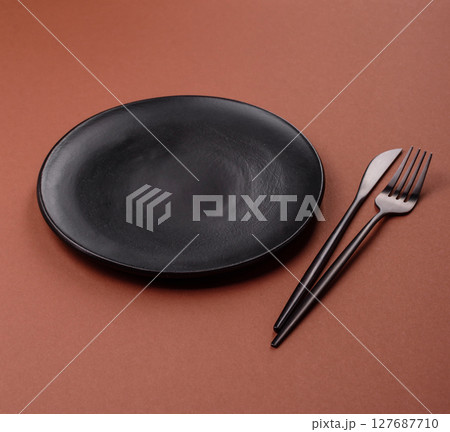 Empty ceramic plate on a monochrome brown background Empty ceramic plate on a monochrome brown background 127687710