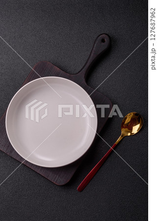 Empty plate with spoon, cutlery for dinner table 127687962